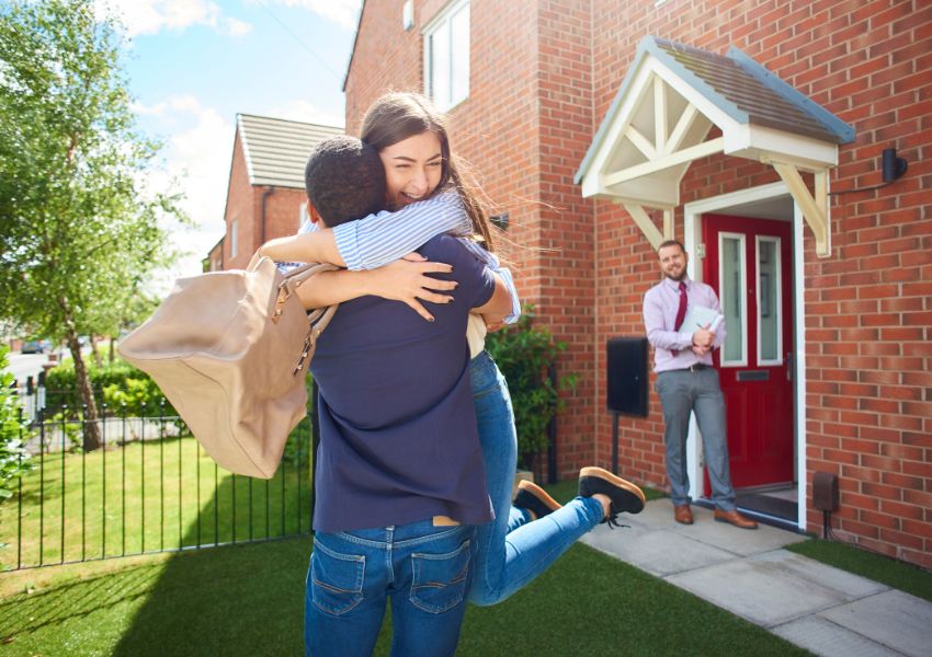two%20people%20hugging%20in%20the%20front%20yard%20of%20their%20new%20rental%20property%20with%20a%20real%20estate%20agent%20in%20the%20background